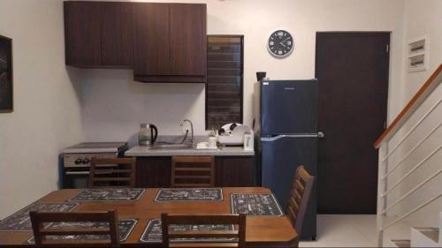 a kitchen with a table and a refrigerator at Mactan Guesthouse in Cogon