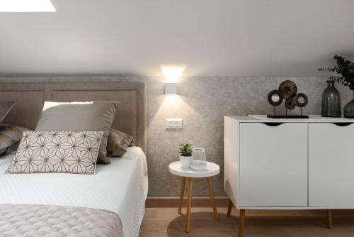 a bedroom with a bed with a white cabinet and a table at Apartment Vala Vrsar in Vrsar