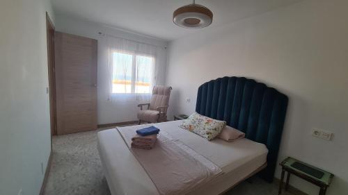 a bedroom with a bed with a blue headboard and a window at Vacaciones de ensueño in Mojácar