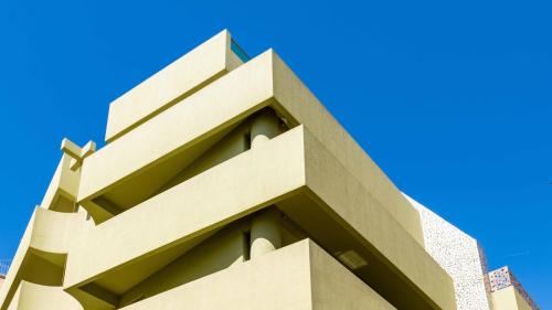 a tall building with a blue sky in the background at Athens Mosaico Suites & Apartments in Athens