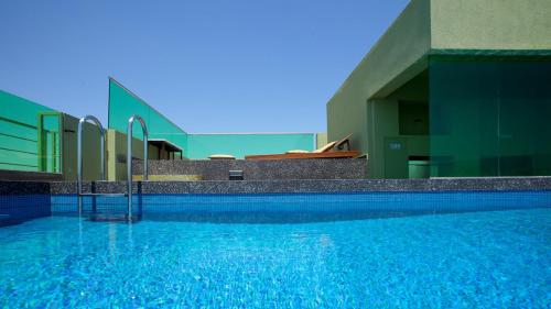 a large swimming pool in front of a building at Athens Mosaico Suites & Apartments in Athens