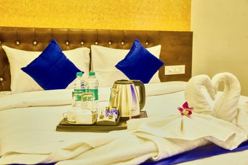 a hotel room with a bed with towels and bottles of water at SM Royal Stay Hotel - Near Bangalore international Airport in Bengaluru