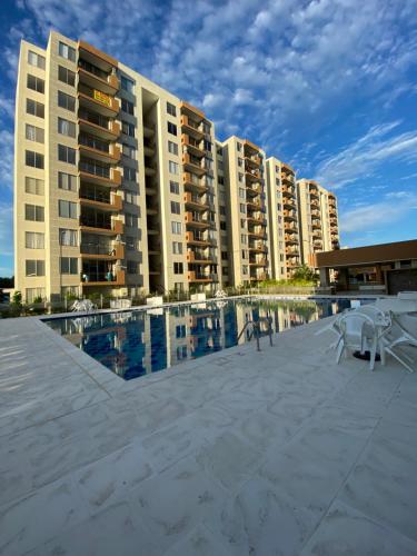 un grand immeuble avec une piscine et des chaises dans l'établissement Apartamento de verano, à San Rafael