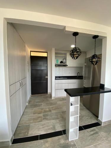 une cuisine avec des armoires blanches et un comptoir noir dans l'établissement Apartamento de verano, à San Rafael