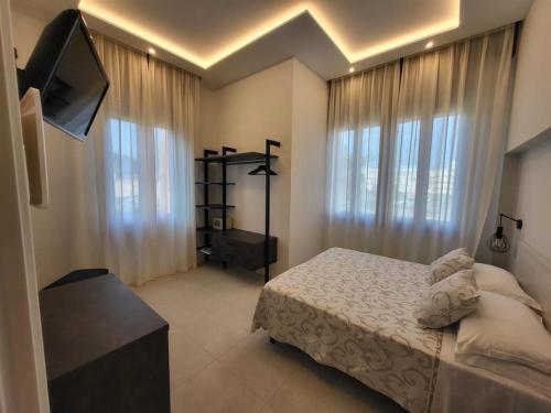 a bedroom with a bed and a flat screen tv at Hotel Villa Fulgida in Cattolica