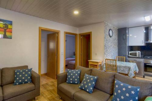 a living room with two couches and a kitchen at Refúgio do Canas in Rapoula do Côa