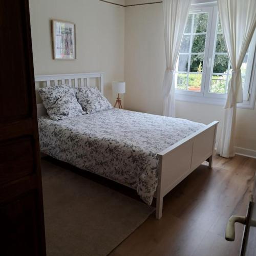 a bedroom with a bed and a window at Grande maison au coeur de la Bretagne in Huelgoat