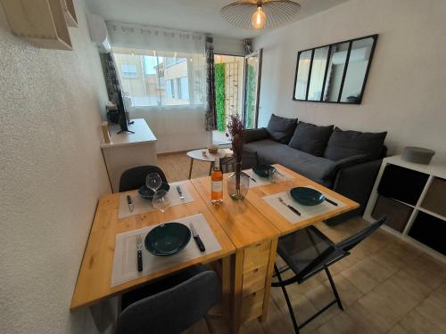 un salon avec une table en bois et un canapé dans l'établissement Studio Cabine Piscine-Clim-Parking-Plage200m, à Valras-Plage