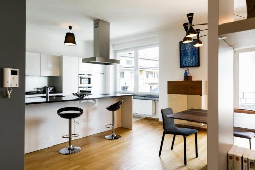 a kitchen and dining room with a table and chairs at Lago Welcome Place d'Armes II in Luxembourg