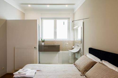 a bedroom with a bed and a bathroom with a sink at Lago Welcome Place d'Armes II in Luxembourg