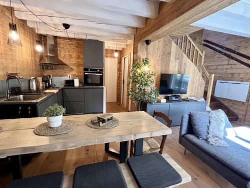 Il dispose d'une cuisine et d'un salon avec une table et des chaises en bois. dans l'établissement Chalet charmant à Saint-Lary-Soulan avec cheminée, à Saint-Lary-Soulan