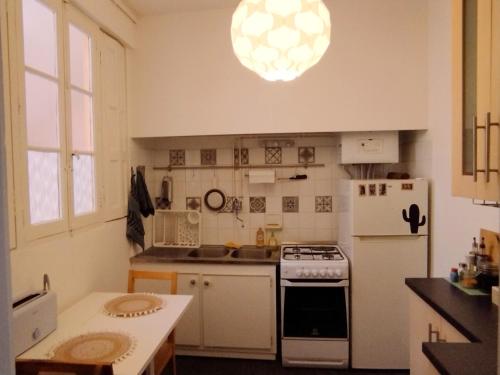 Il comprend une cuisine équipée d'une cuisinière et d'un réfrigérateur blanc. dans l'établissement La casa del mundo, à Toulouse