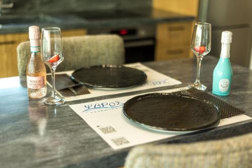 a table with two empty plates and wine glasses at Peristeres Luxury Apartment Next To The Sea - BY APOKORAS VILLAS in Almirida