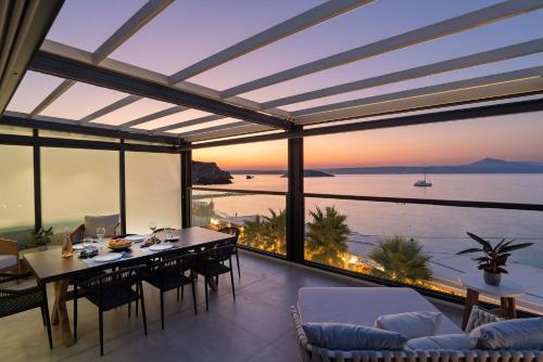 a dining room with a view of the ocean at Peristeres Luxury Apartment Next To The Sea - BY APOKORAS VILLAS in Almirida