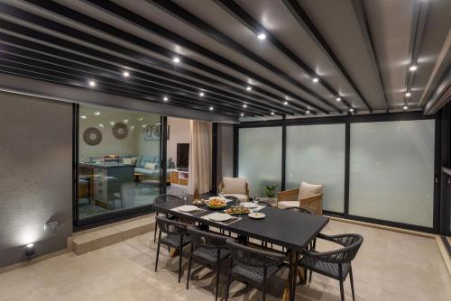 a dining room with a table and some chairs at Peristeres Luxury Apartment Next To The Sea - BY APOKORAS VILLAS in Almirida