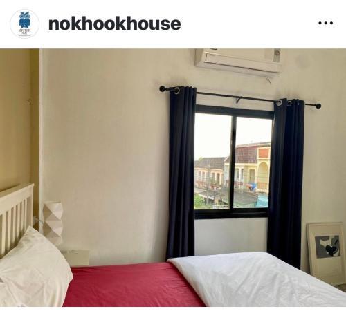 a bedroom with a bed and a window at Nokhook House in Trang