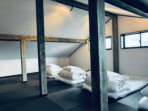 two bunk beds in a room with windows at Hostel SAMURISE 81INN in Fujikawaguchiko