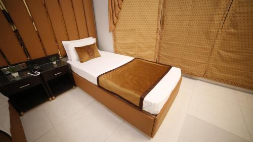 a small bed in a room with a window at Four Squares by WI Hotel in Karachi