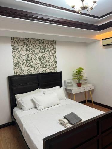 a bedroom with a large bed with a black headboard at Kay Hotel and Residences in Angeles