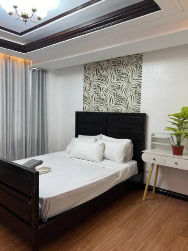 a bedroom with a large bed with a black headboard at Kay Hotel and Residences in Angeles