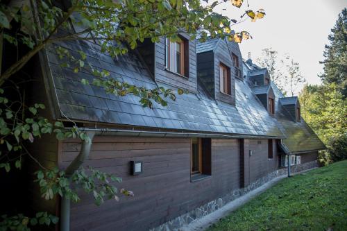 a house with a gambrel roof on the side of it at Penzion Ovečka in Nýdek