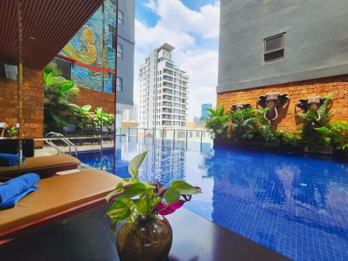 a large swimming pool in a building with a large window at Poulo Wai Hotel & Apartment in Phnom Penh