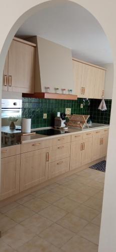 - une cuisine avec des placards en bois et du carrelage vert dans l'établissement Gîte ensoleillé, au calme, proche Montségur, à Fougax-et-Barrineuf