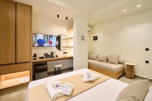 a room with a bed and a couch and a tv at Monarco Executive Rooms in Rhodes Town
