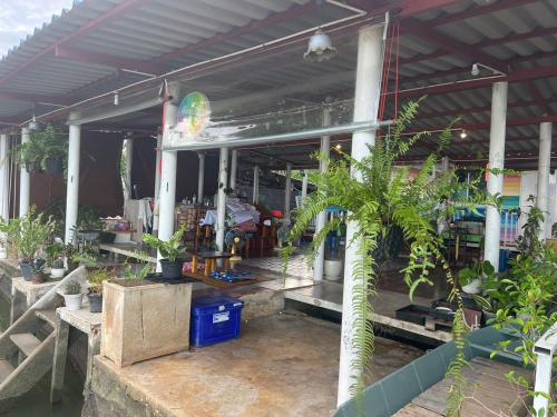 a building with a bunch of potted plants in it at Se'sun Amphawa in Amphawa