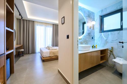 a bathroom with a sink and a toilet and a bed at Monarco Executive Rooms in Rhodes Town