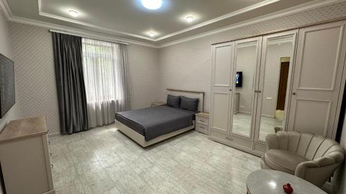 a bedroom with a bed and a chair in it at Lux Home in heart of city center in Vanadzor