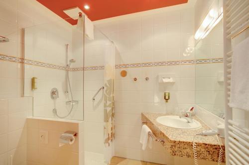 een witte badkamer met een wastafel en een douche bij Elisabeth Hotel garni in Detmold