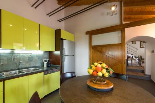 a kitchen with a table with a bowl of fruit on it at Saracina in Aci Catena