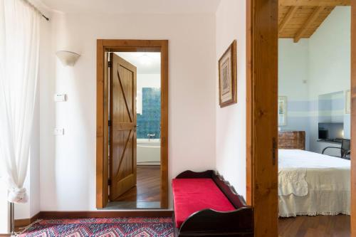 a bedroom with a bed and a red bench at Saracina in Aci Catena