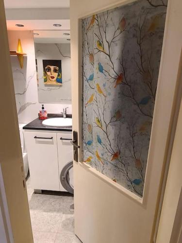a bathroom with a toilet and a sink and a door at Loft Apartment Jabal Amman A in Amman