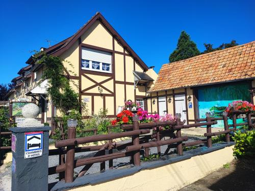 a building with a wooden fence in front of it at Le Vieux Logis in Neufchâtel-Hardelot