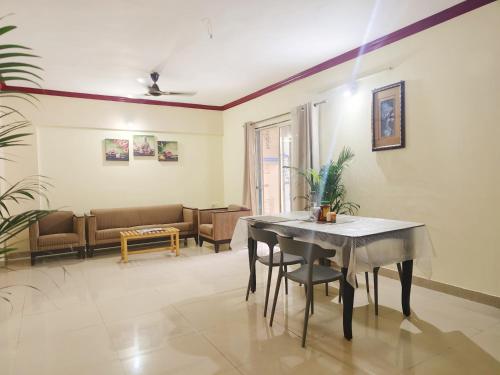 a living room with a table and a couch at Private Room In Viman Nagar in Viman Nagar