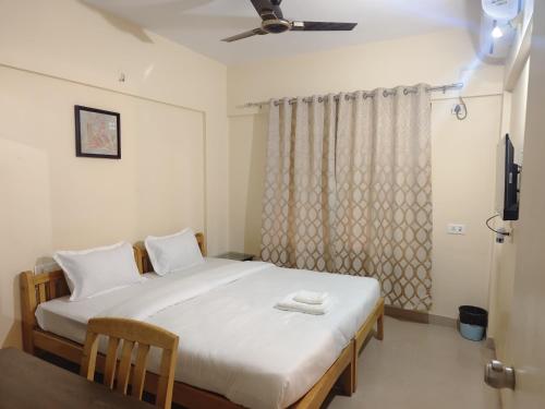 a bedroom with a white bed with a window at Private Room In Viman Nagar in Viman Nagar