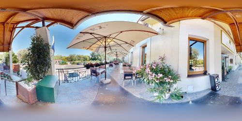 a patio with tables and umbrellas in a building at Hotel Hradna brana in Bratislava