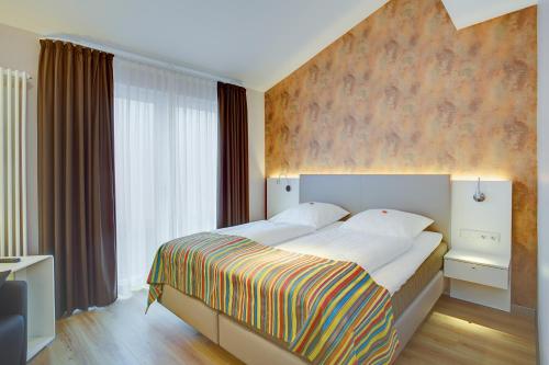 een slaapkamer met een groot bed en een groot raam bij Elisabeth Hotel garni in Detmold