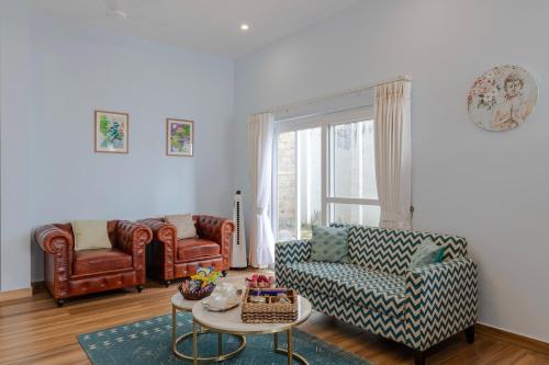 a living room with a couch and a table at ELIVAAS 3 BHK with Garden & Scenic Views - Alpenglow in Kasauli