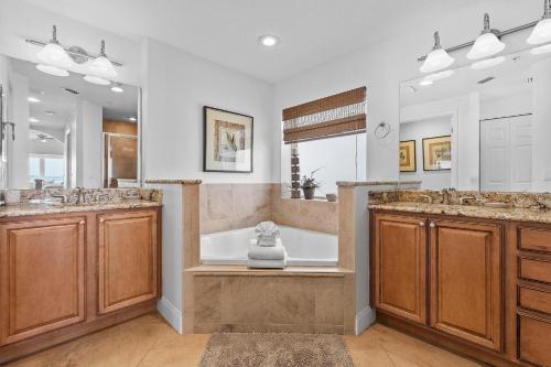 a large bathroom with two sinks and a tub at Atlantic Villas 301 in New Smyrna Beach