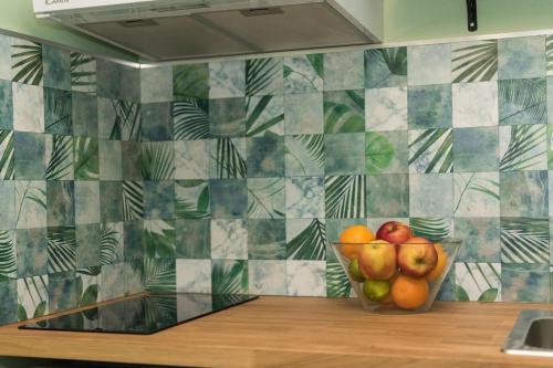 un bol de pommes et d'oranges sur un comptoir dans une cuisine dans l'établissement Appartement Botanique, à Lille