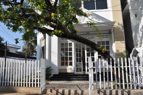 a white picket fence in front of a white house at Daffodils Spice Court in Cochin