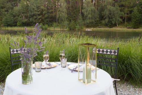 a white table with wine glasses and flowers on it at Hotel Seehof Nature Retreat in Naz-Sciaves