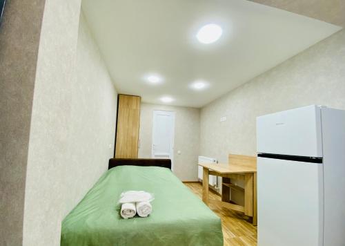 a small room with a bed and a refrigerator at Park flat in Borjomi