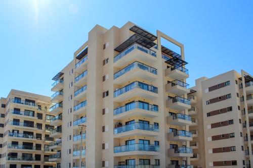 an apartment building against a blue sky at Luxury Family Apartment #28 By Hashdera Eilat in Eilat