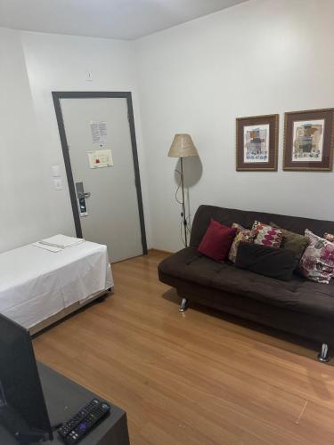 a living room with a couch and a bed at Apart-Hotel de Luxo em Lourdes in Belo Horizonte