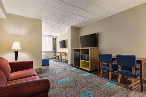 a room with a couch and chairs and a television at Days Hotel by Wyndham Allentown Airport / Lehigh Valley in Allentown