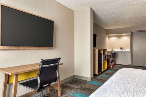 a hotel room with a desk and a flat screen tv at Days Hotel by Wyndham Allentown Airport / Lehigh Valley in Allentown